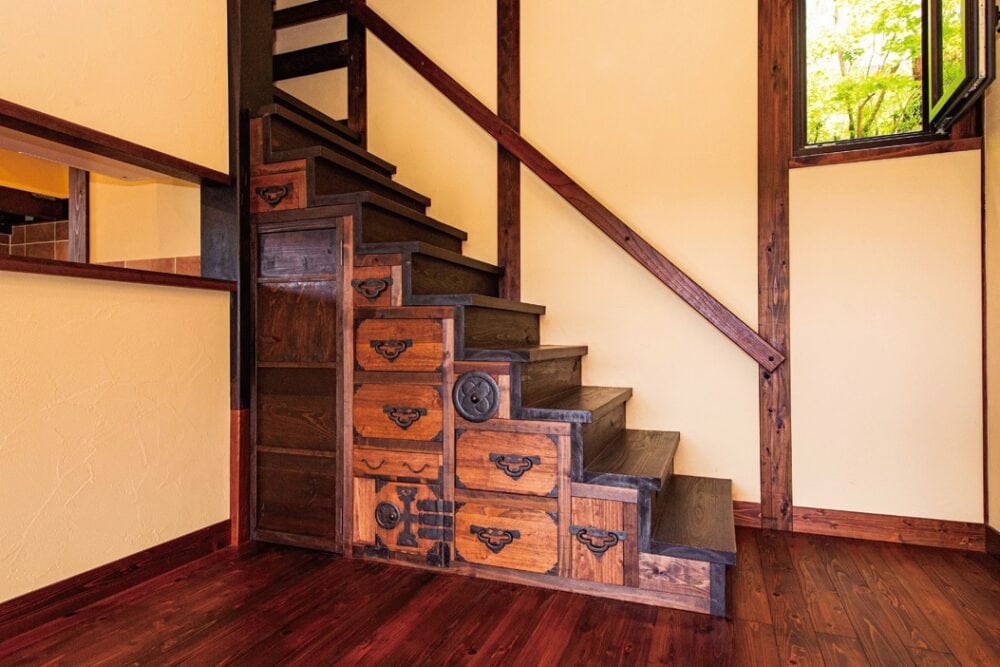 施工した大工さんが遊び心で、昔の板戸や蔵の戸でつくった階段箪笥。