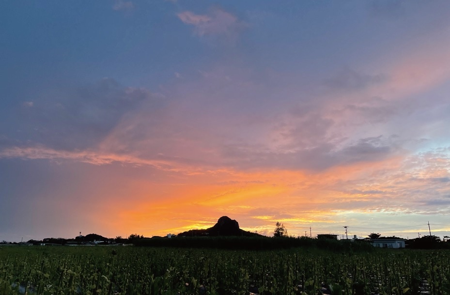 島のシンボル城山に夕日が沈む（沖縄県伊江村）