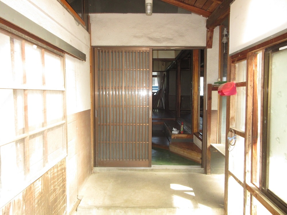 岩手県遠野市の物件の玄関。母屋と小屋をつなぐL字部分の中心に玄関がある。