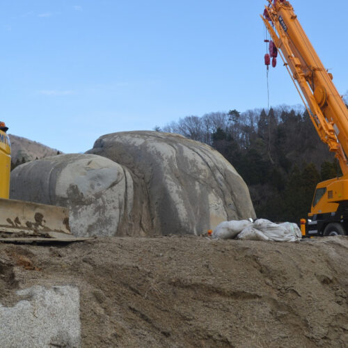 田村市の工事現場で見つかった巨石。左の重機が小さく見えるほどの大きさです。