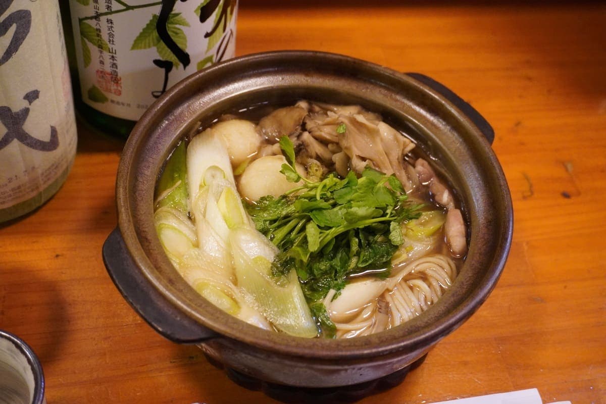 秋田県能代市の白神ねぎ入りだまこ鍋。鶏ガラだしのスープに鶏肉や野菜を入れて煮込み、すり鉢でつぶしたご飯を丸めた「だまこ」を入れた秋田県の郷土料理。能代市ではここに、特産の「白神ねぎ」を入れます。冬に収穫される白神ねぎは一段と柔らかく、とろけるような味わいが特徴です。