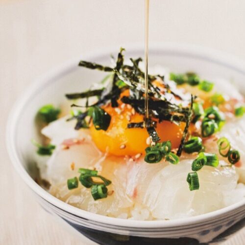 宇和島スタイルの「鯛めし」は、生卵を溶いたダシ汁にタイの刺身・海藻・薬味を混ぜ合わせ、熱々のご飯にかけていただく。