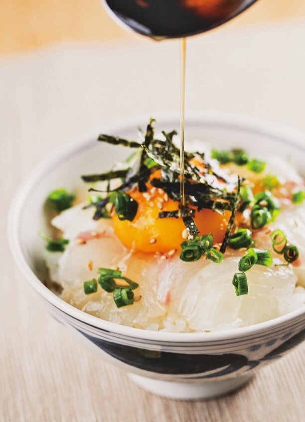 宇和島スタイルの「鯛めし」は、生卵を溶いたダシ汁にタイの刺身・海藻・薬味を混ぜ合わせ、熱々のご飯にかけていただく。