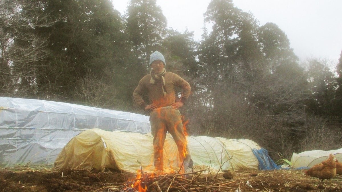 集めた枯れ木で焚き火。火が落ち着いてから周辺に鍬を入れると、黒い土が出てくる。