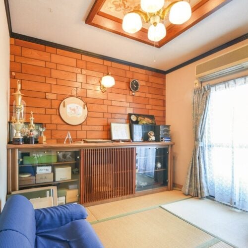 愛媛県宇和島市の物件の玄関横の和室は、板張りの壁やブラケット、折り上げ天井など、和モダンな空間。