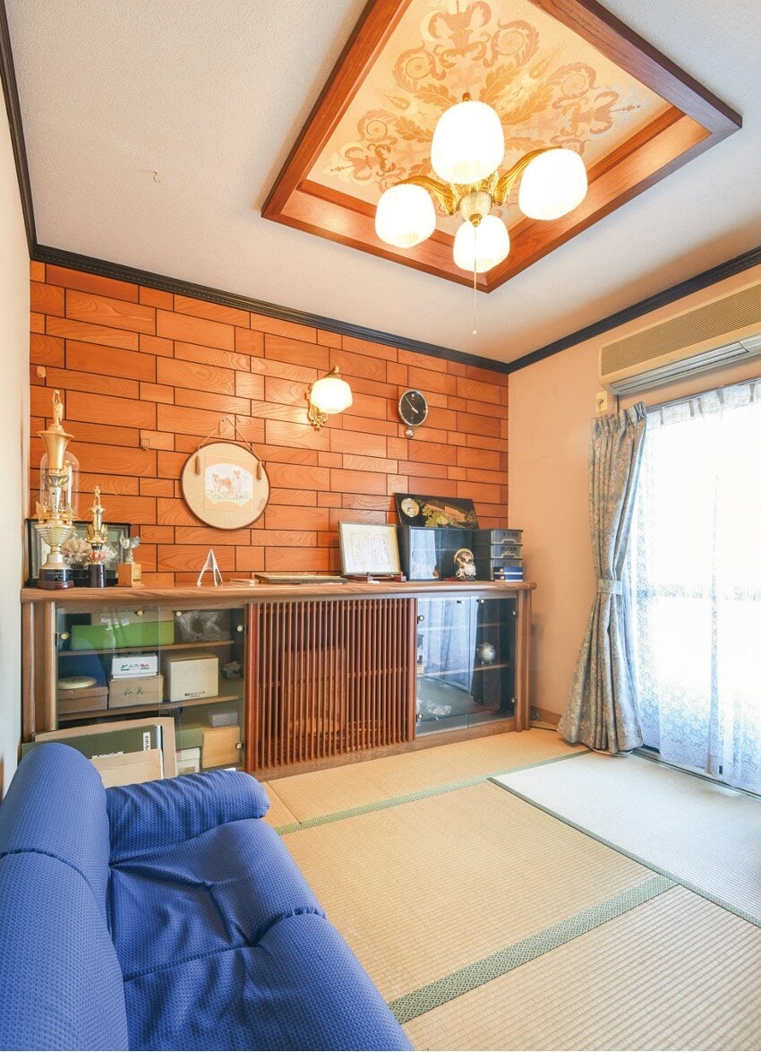 愛媛県宇和島市の物件の玄関横の和室は、板張りの壁やブラケット、折り上げ天井など、和モダンな空間。