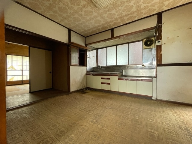 長野県駒ケ根市の物件の14.5帖のダイニングキッチン。建築当時のままなのでキッチンは老朽化が進んでいます。床にも傷みが見られるので全体的に改修を検討する必要がありそうです。