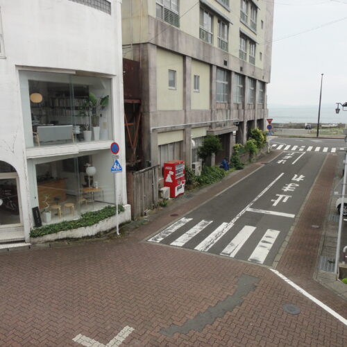 長崎県雲仙市の物件の2階の窓からの景色です。広く開けた道路の向こうに、海を眺めることができます。