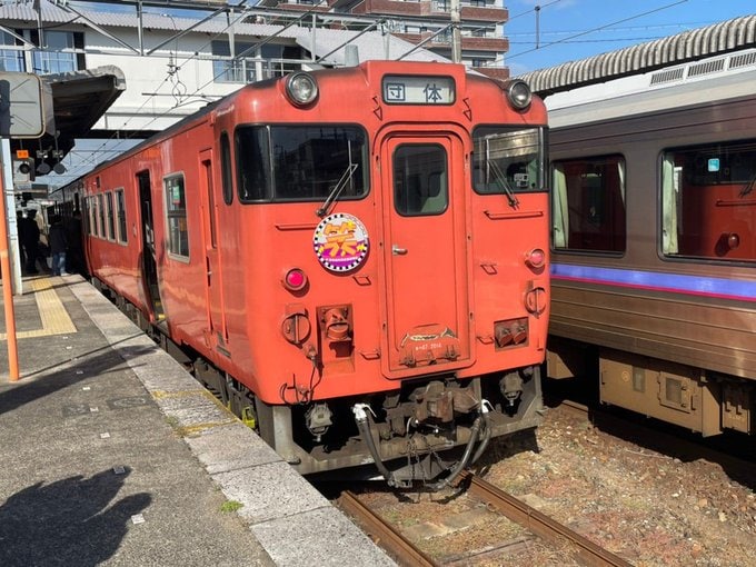 2024年3月に全線開通100周年を迎えた美祢線のプレ記念事業として、特別なヘッドマークを付けた特別列車「お笑い列車 IN 美祢線」が厚狭駅を出発したところです。