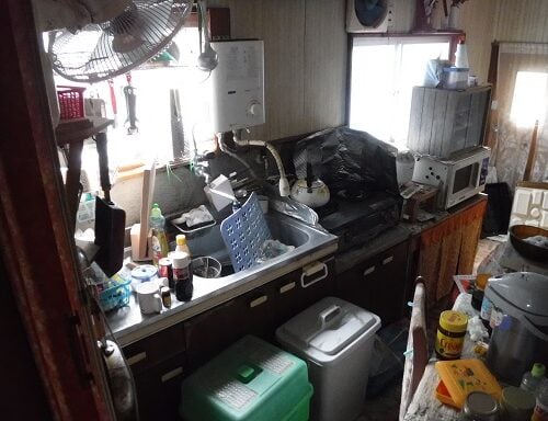 愛媛県西予市の物件のキッチンです。ガスコンロと給湯器が装備されています。状態は残留物撤去後に確認を。