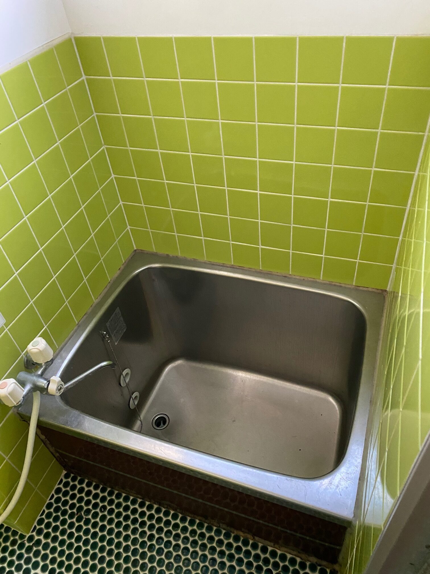 岩手県久慈市の物件のグリーンのタイルがさわやかな浴室は、使用感はありますが、このまま使うことも可能です。気になる場合はリフォームを検討しましょう。
