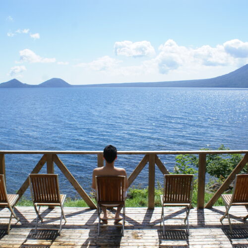 北海道支笏湖畔に佇む丸駒温泉旅館のととのいスペースからは支笏湖が一望できる。