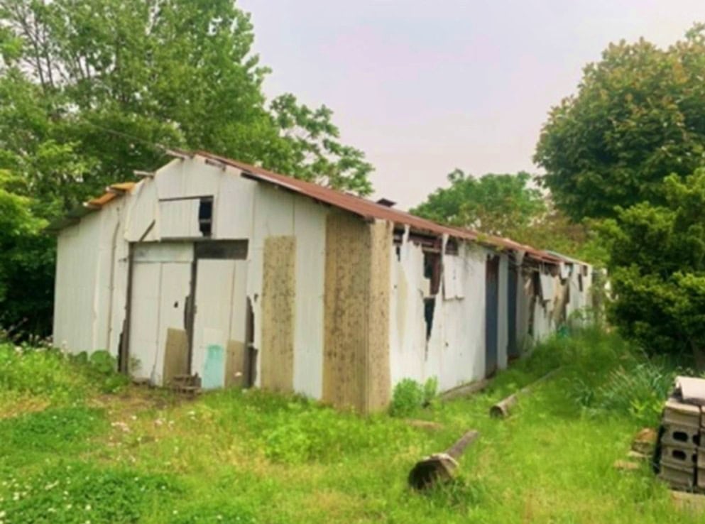 青森県つがる市の物件の敷地内に立つ小屋。古く壊れているので撤去したほうがよさそうです