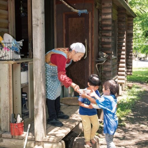 調理するのは隣に住む杉井さんの母、通称「バービー」。大皿を受け取り園舎に運ぶのは子どもたちの役目。里山保育やまっこかわっこ／東京都檜原村