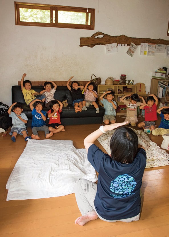 小さい子たちのお昼寝タイムを前に室内で歌や紙芝居。気持ちをゆったり整えて いく。里山保育やまっこかわっこ／東京都檜原村