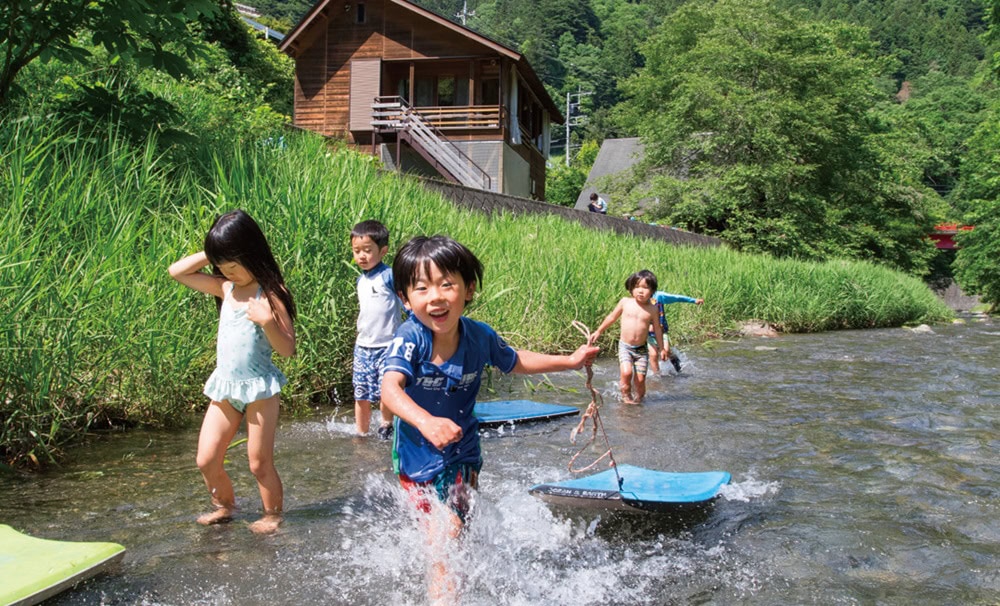 子どもたちは川遊びが大好き。初夏から秋口まで晴れた日の自由時間は、園庭の前の川で遊ぶのが日常。里山保育やまっこかわっこ／東京都檜原村