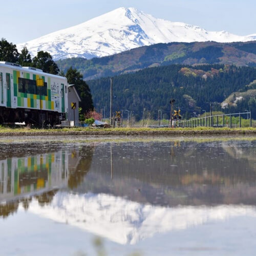 秋田県由利本荘市の由利高原鉄道の「おばこ号」です。東北屈指の名山「鳥海山」を仰ぎながら、秋田の米どころ由利地域の美田地帯を子吉川に沿ってゆっくりと走るローカル列車と、田植えの時期に水鏡に映る「逆さ鳥海山」とのコラボレーションは必見です。