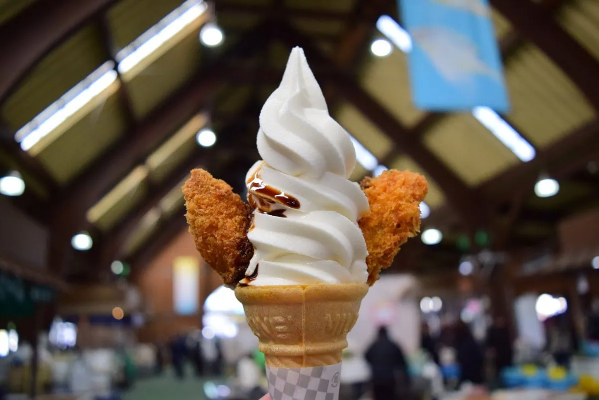 岡山県備前市の五味の市で味わう事ができる、日生特産の牡蠣をソフトクリームにトッピングした「カキフライソフトクリーム」です。小豆島の刺身醤油をかけていただきます。