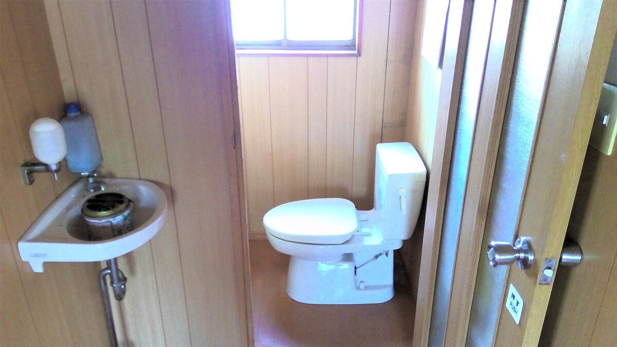 鹿児島県肝付町の物件の1階のトイレは簡易水洗の洋式トイレです。窓があり換気もできます。トイレの前には手洗いも設けられています。1階トイレは、来客も使用することになるので、離れにあるトイレと使い分けてもよいかもしれません。