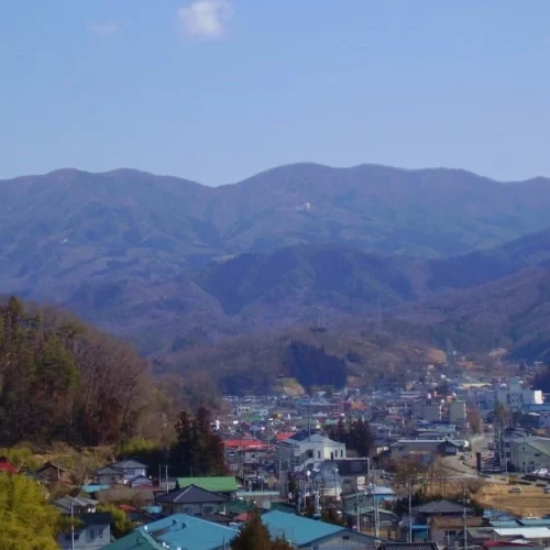 福島県の川俣町と飯館村にまたがる「花塚山（はなづかやま）」は、両町村の最高峰。川俣町側の麓には「花塚の里」や「峠の森自然公園」があります。標高約890mの花塚台からは、太平洋を望むことができ、川俣盆地や安達太良（あだたら）連峰が一望できます。また、条件が整った冬の期間には山頂付近から富士山が遠望でき、富士山の見える北限としても知られています。