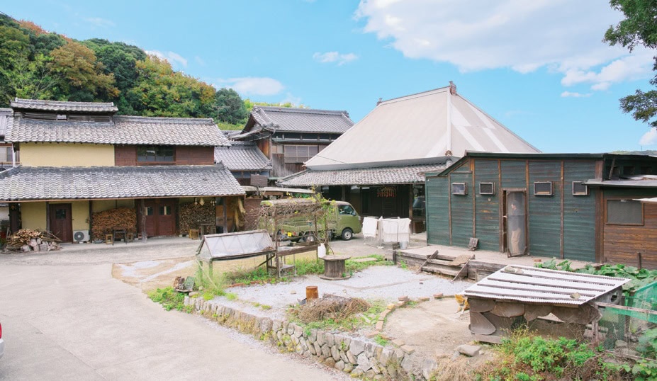 吉川家全景。手前の緑の平屋がパン屋棟。真ん中は築150年の母屋、左の特徴的な屋根の納屋がカフェ／「りすのくつ」（香川県三豊市）