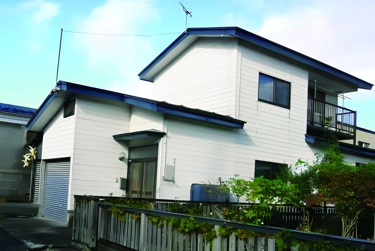 秋田県能代市の物件の外観。白い外壁の二階建て