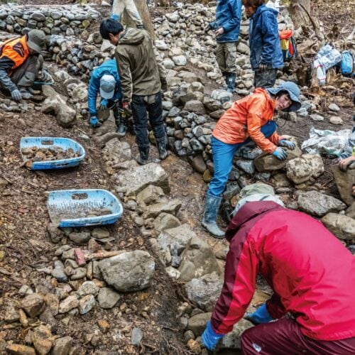 崩れた谷の沢に石を積んで緩やかな流れを再生しながら土壌を安定させるワークショップ／福井県南越前町