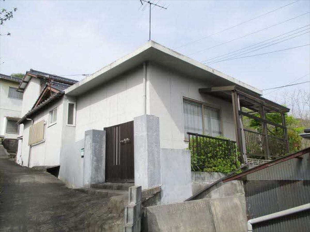 岡山県備前市の物件の外観。傾斜地を上がったところに立つ。
