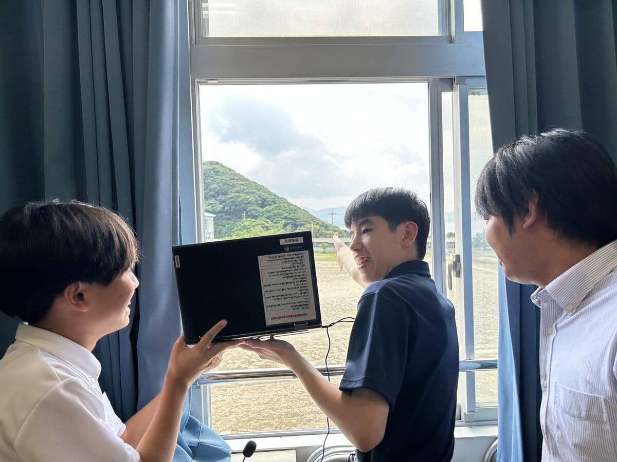 タブレットで窓の外を映し、自分たちのまちを紹介する生徒たち。