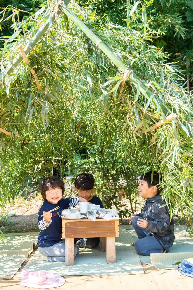 「楽しい暮らしサポーターズ事務局」のイベントにて。完成した竹の基地に入って、良子さんお手製のおにぎりと豚汁でお昼ごはん。3歳から11歳まで、7人の子どもたちが参加した/大分県豊後高田市