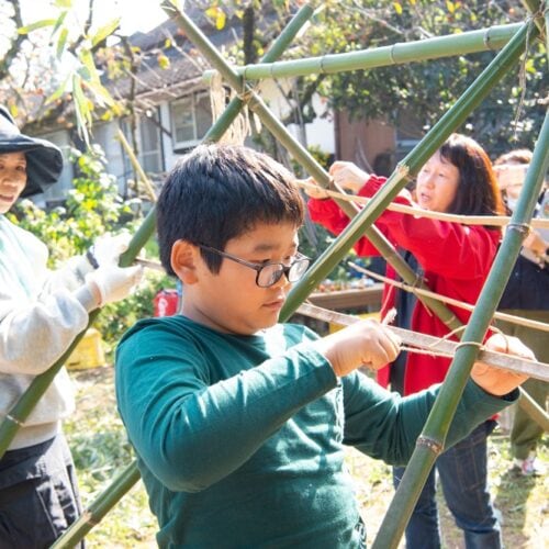 切った竹を交差させて紐で縛り、家の骨組みをつくっていく。最年長11歳の男の子は、この日のリーダーともいえる活躍ぶり/大分県豊後高田市