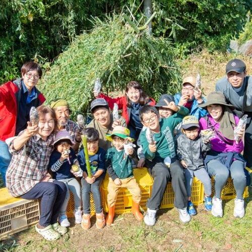 基地をバックに記念撮影。市中心部在住の親子、移住者親子など参加者の顔ぶれもさまざまだった/大分県豊後高田市