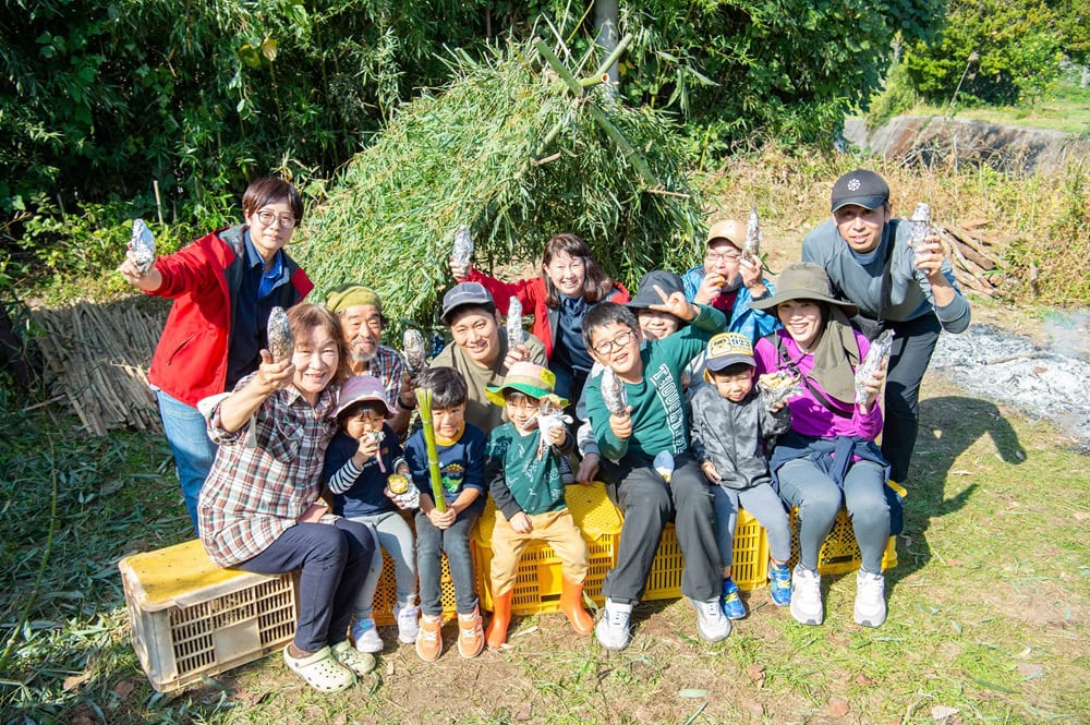 基地をバックに記念撮影。市中心部在住の親子、移住者親子など参加者の顔ぶれもさまざまだった/大分県豊後高田市
