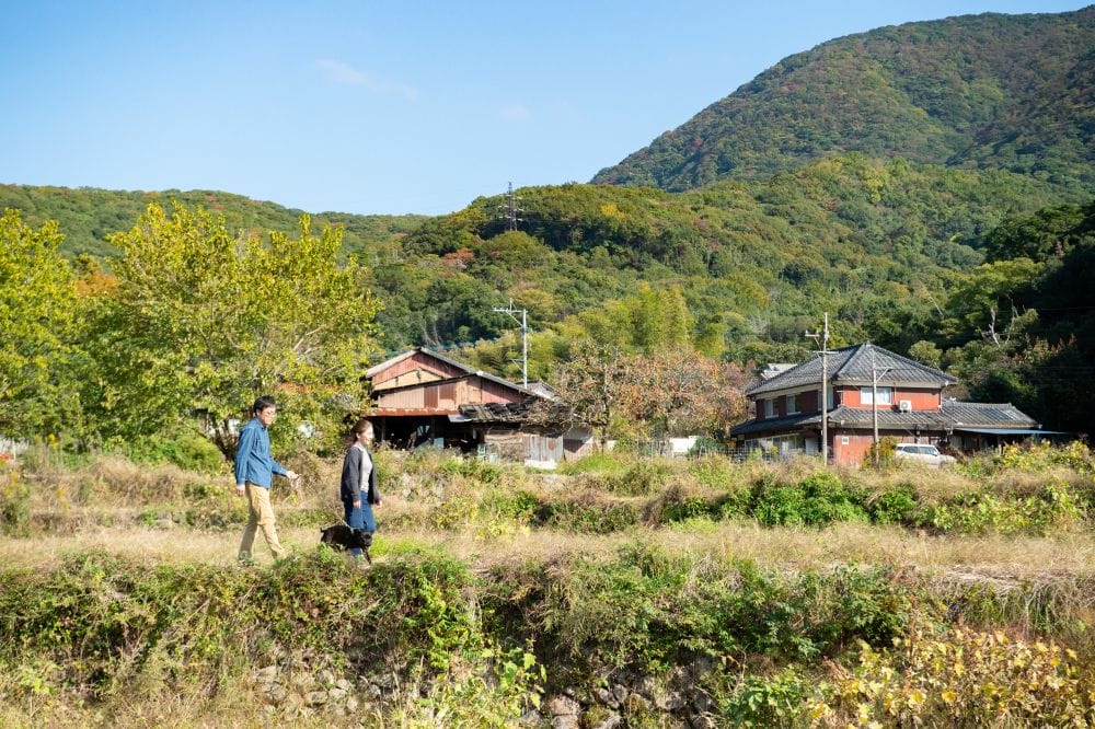 愛犬のおかかくんと近所のお散歩コースで。「家の周囲ののどかな風景がいちばんのお気に入り。真玉温泉や夷谷温泉にもよく行きます」と浩一さん/大分県豊後高田市「cavan」