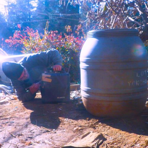 金属製の耳かきを使ってポータブル電源の端子を調整する細かなメンテナンス作業