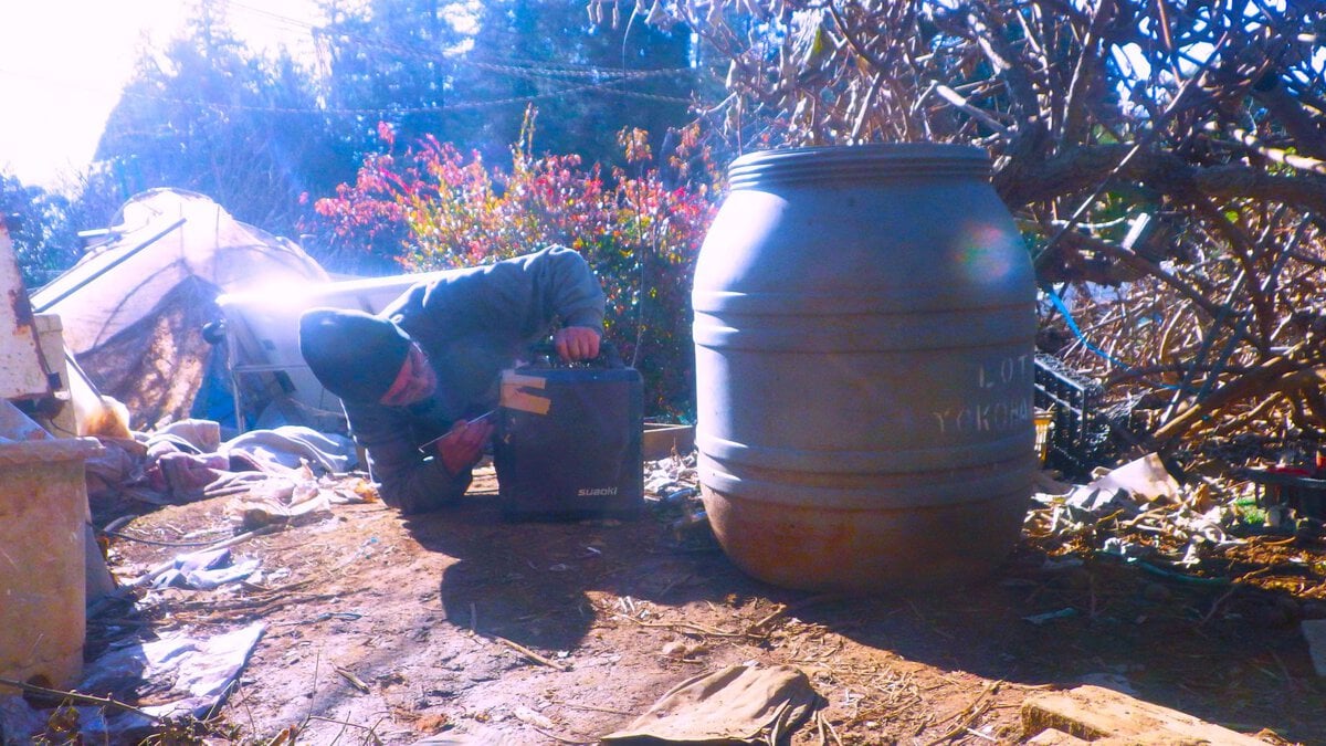 金属製の耳かきを使ってポータブル電源の端子を調整する細かなメンテナンス作業